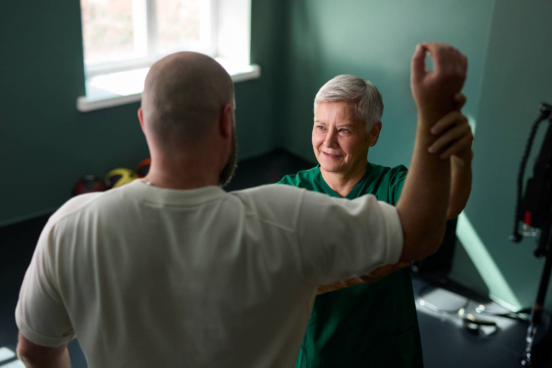 Fysioterapeutti tutkii vastaanotolla asiakkaan liikettä.