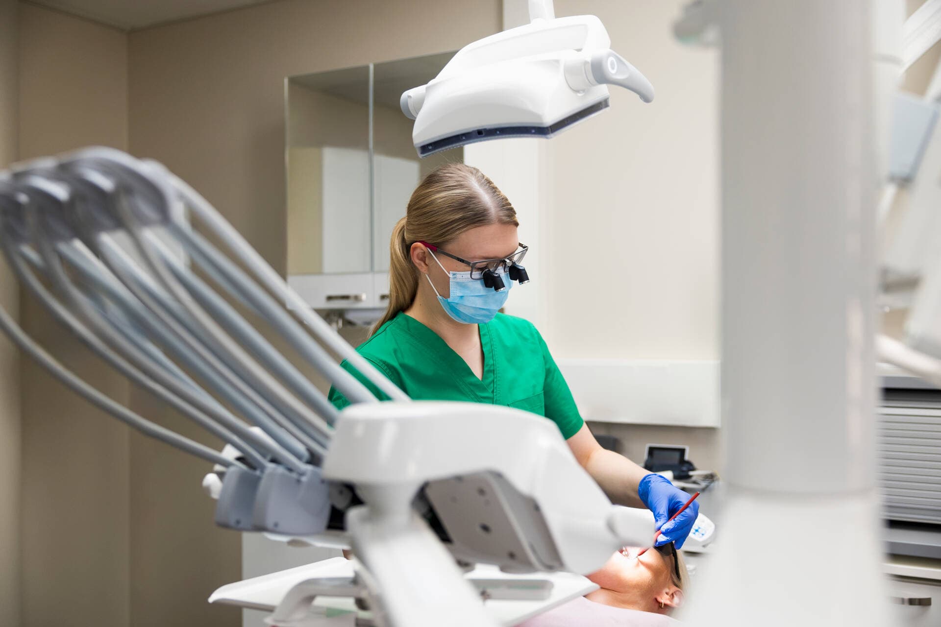 The female dentist is wearing examination glasses.