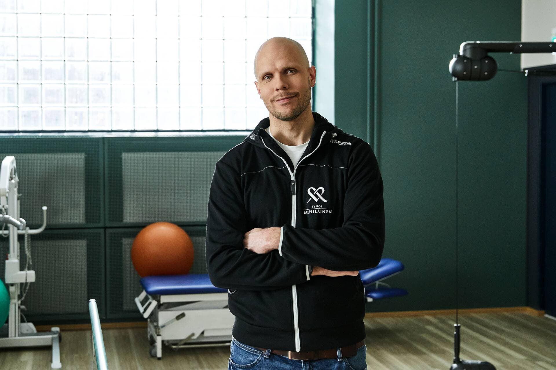 Mehiläisen fysioterapeutti ja terapeuttisen harjoittelun välineitä taustalla.